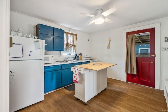 96 Ems B61I Ln, Warsaw, IN 46582 - kitchen featuring white appliances, blue cabinetry, a sink, wood finished floors, and butcher block counters