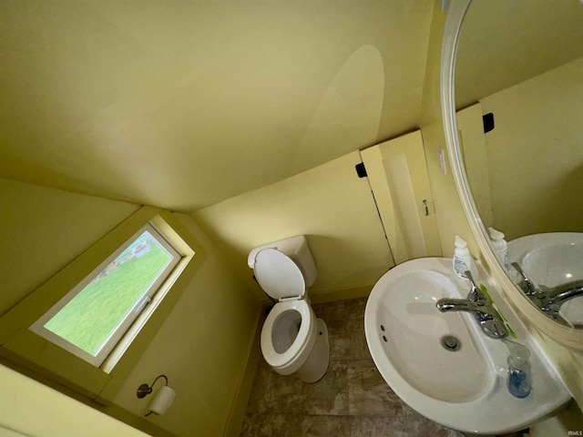 417 S Elliott St, Muncie, IN 47305 - bathroom with lofted ceiling, a sink, toilet, and baseboards