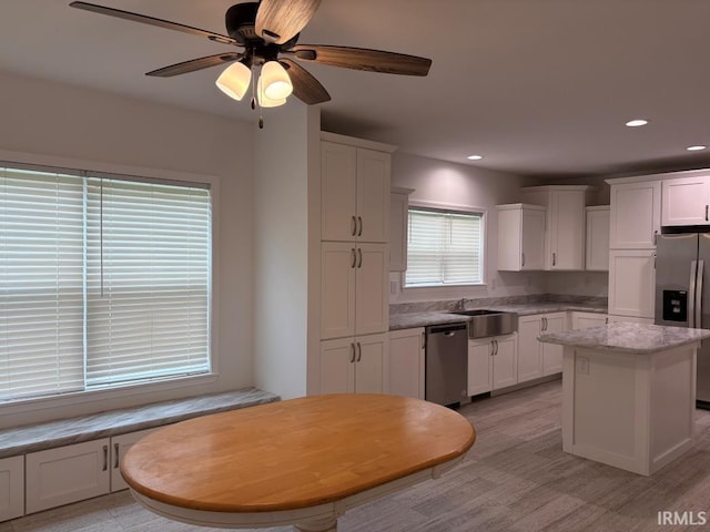 844 Ben Franklin St, Cloverdale, IN 46120 - kitchen featuring appliances with stainless steel finishes, a sink, white cabinets, a center island, and light wood-style flooring