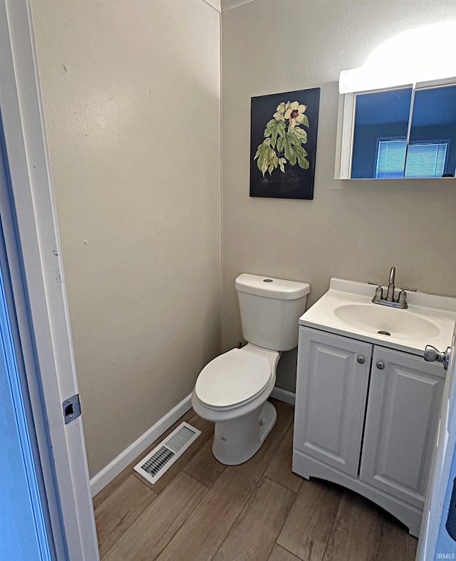 402 Sheridan St, Loogootee, IN 47553 - bathroom featuring vanity, toilet, wood finished floors, and baseboards