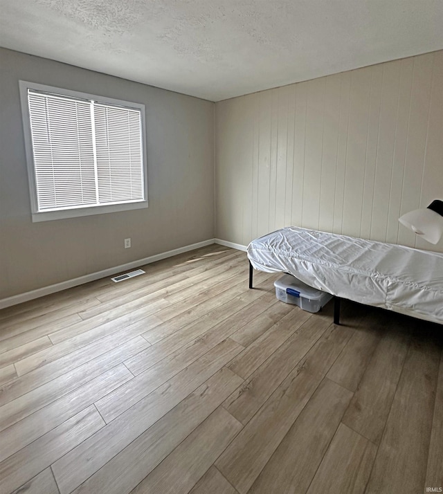 402 Sheridan St, Loogootee, IN 47553 - bedroom featuring wood finished floors, a textured ceiling, and baseboards