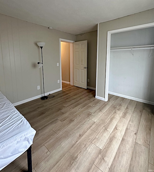 402 Sheridan St, Loogootee, IN 47553 - unfurnished bedroom with wood finished floors, a closet, and baseboards