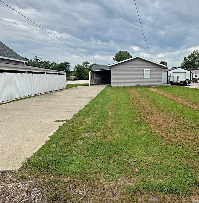 402 Sheridan St, Loogootee, IN 47553 - view of side of home featuring driveway, a yard, and a carport