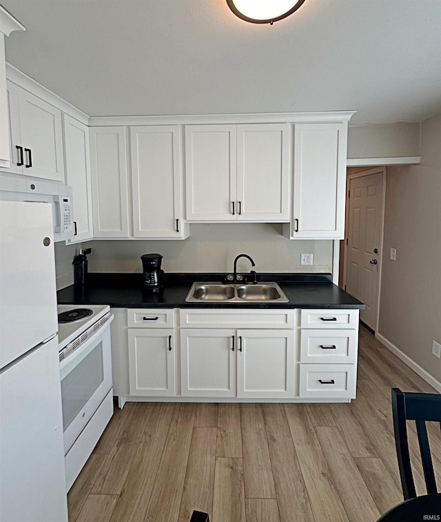 402 Sheridan St, Loogootee, IN 47553 - kitchen featuring white appliances, a sink, light wood-style floors, and dark countertops