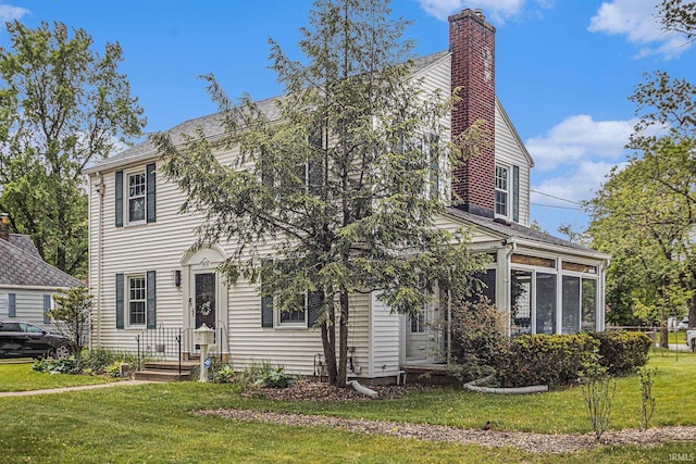 1919 Kessler Blvd, South Bend, IN 46616 - view of front facade featuring a chimney, a front lawn, and a sunroom