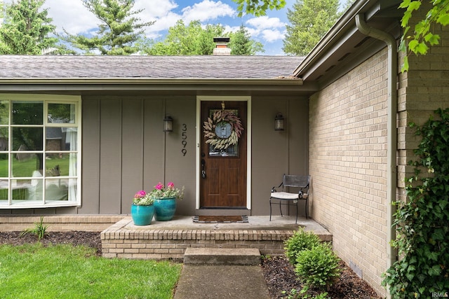 3599 Canterbury Dr, Lafayette, IN 47909 - view of exterior entry with a porch, a chimney, board and batten siding, and roof with shingles