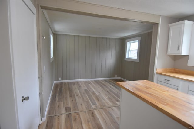 1602 Etna Ave, Huntington, IN 46750 - unfurnished dining area with light wood-style flooring, baseboards, and wood walls