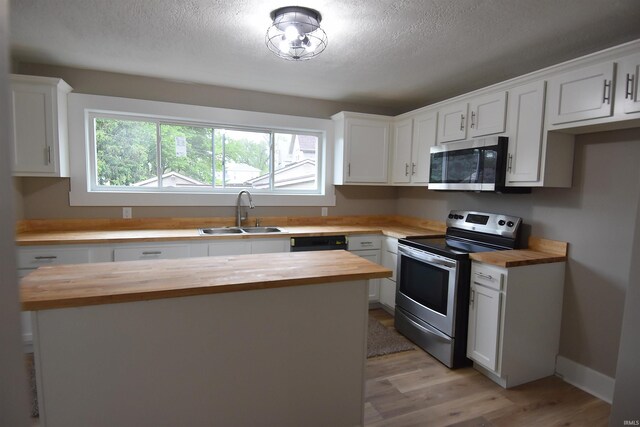 1602 Etna Ave, Huntington, IN 46750 - kitchen featuring wooden counters, appliances with stainless steel finishes, a sink, light wood finished floors, and a textured ceiling