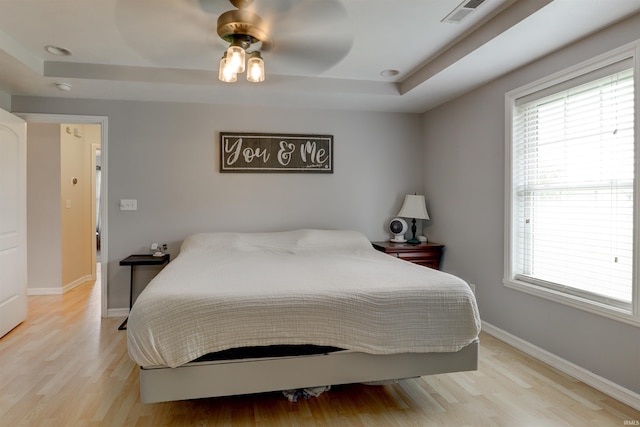1444 Field Crest Ln, Jasper, IN 47546 - bedroom with a tray ceiling, light wood-type flooring, and multiple windows