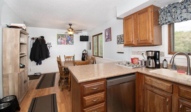 1220 N 290, Angola, IN 46703 - kitchen featuring stainless steel dishwasher, a peninsula, light wood finished floors, a textured ceiling, and brown cabinets