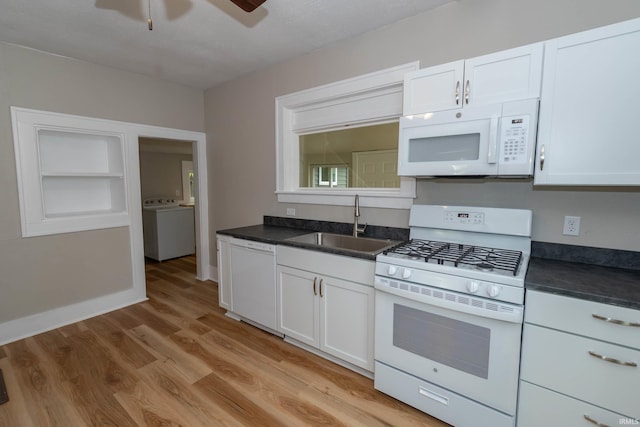 515 W Crawford St, Elkhart, IN 46514 - kitchen featuring white appliances, washer / dryer, a sink, dark countertops, and light wood-type flooring