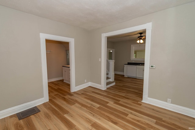 515 W Crawford St, Elkhart, IN 46514 - unfurnished room featuring baseboards, ceiling fan, light wood-style floors, and a textured ceiling