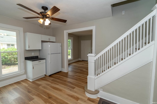 515 W Crawford St, Elkhart, IN 46514 - kitchen with freestanding refrigerator, light wood-style flooring, baseboards, dark countertops, and ceiling fan