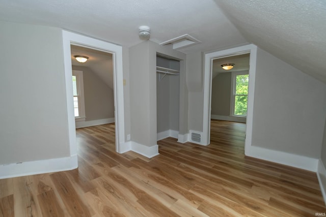 515 W Crawford St, Elkhart, IN 46514 - bonus room with lofted ceiling, light wood-type flooring, a textured ceiling, and baseboards