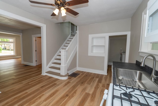 515 W Crawford St, Elkhart, IN 46514 - kitchen featuring a sink, light wood-style flooring, ceiling fan, baseboards, and washer / clothes dryer