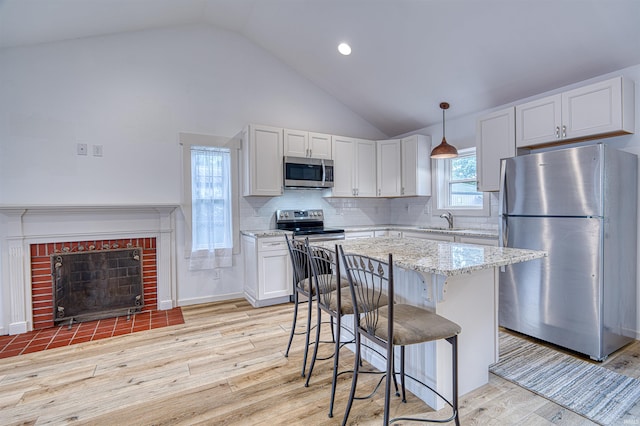 508 Polk St, Newburgh, IN 47630 - kitchen with appliances with stainless steel finishes, a sink, vaulted ceiling, light wood finished floors, and white cabinets