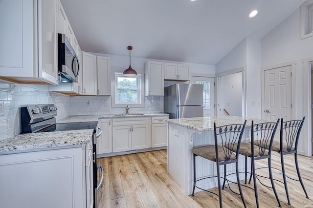 508 Polk St, Newburgh, IN 47630 - kitchen featuring stainless steel appliances, a sink, vaulted ceiling, light wood-style floors, and white cabinetry