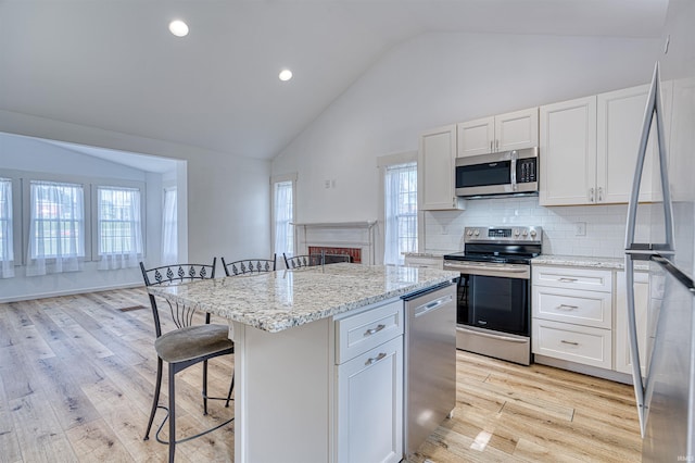 508 Polk St, Newburgh, IN 47630 - kitchen featuring stainless steel appliances, high vaulted ceiling, a kitchen bar, a center island, and white cabinetry