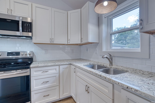 508 Polk St, Newburgh, IN 47630 - kitchen featuring stainless steel appliances, a sink, tasteful backsplash, white cabinetry, and lofted ceiling
