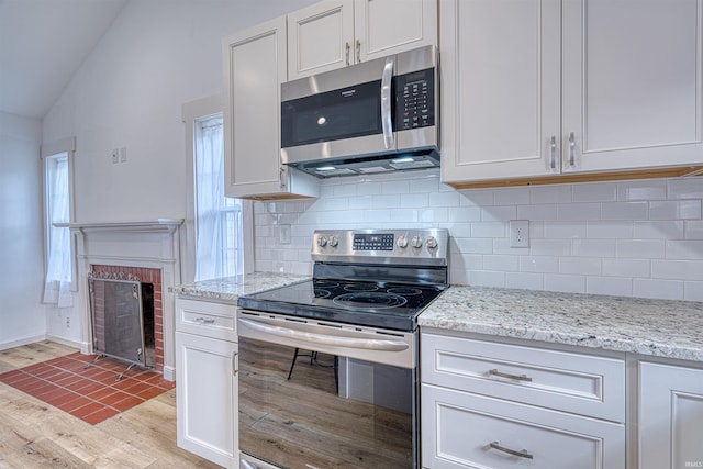 508 Polk St, Newburgh, IN 47630 - kitchen featuring appliances with stainless steel finishes, lofted ceiling, light wood-style flooring, tasteful backsplash, and light stone countertops