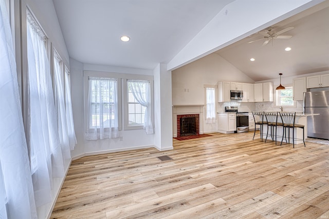 508 Polk St, Newburgh, IN 47630 - living room with light wood-style flooring, a ceiling fan, recessed lighting, a brick fireplace, and high vaulted ceiling