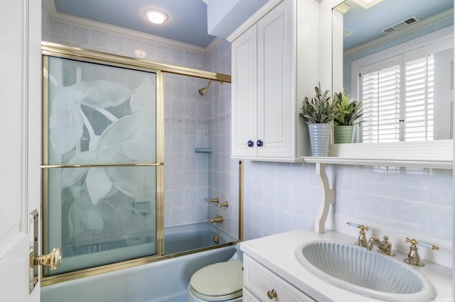2314 Turnberry Ln, Fort Wayne, IN 46814 - bathroom featuring vanity, bath / shower combo with glass door, tile walls, toilet, and crown molding