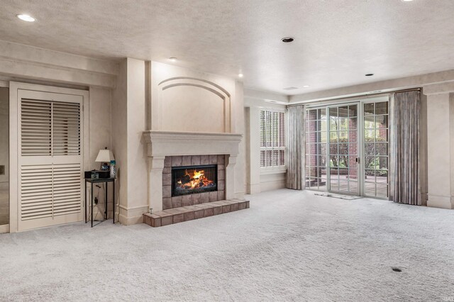 2314 Turnberry Ln, Fort Wayne, IN 46814 - unfurnished living room featuring a tiled fireplace, carpet, a textured ceiling, and recessed lighting