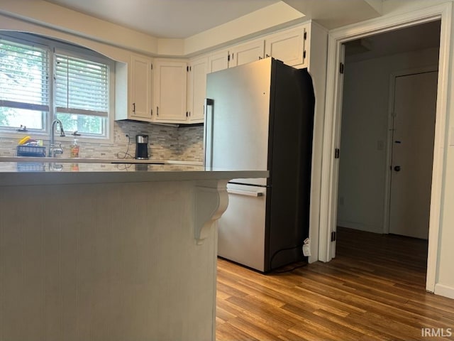 10704 Longwood Dr, Fort Wayne, IN 46845 - kitchen with freestanding refrigerator, white cabinets, wood finished floors, tasteful backsplash, and a sink