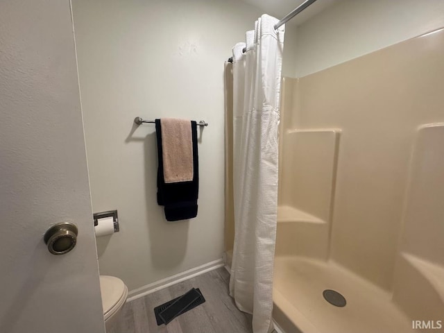10704 Longwood Dr, Fort Wayne, IN 46845 - full bathroom with wood finished floors, curtained shower, toilet, and baseboards