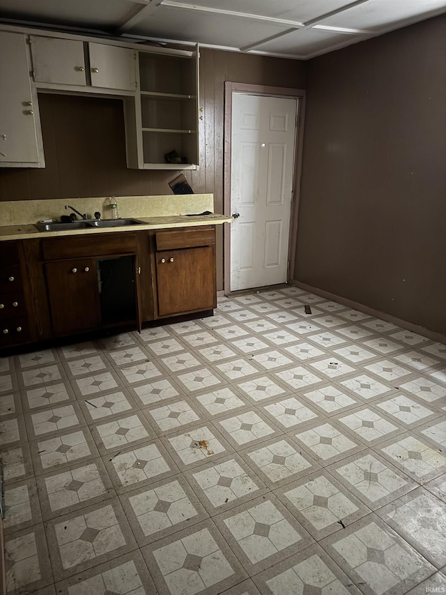 1018 E Main St, Muncie, IN 47305 - kitchen featuring a sink, light countertops, open shelves, baseboards, and light flooring