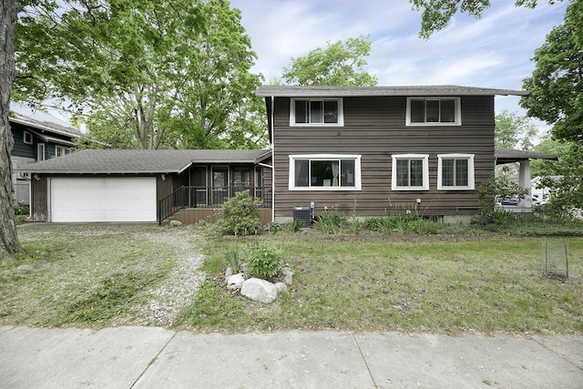 318 E Monroe St, Goshen, IN 46526 - view of front of home with a garage, a sunroom, driveway, and a front lawn