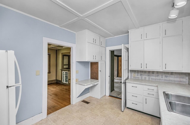 318 E Monroe St, Goshen, IN 46526 - kitchen with freestanding refrigerator, light countertops, white cabinets, and a sink