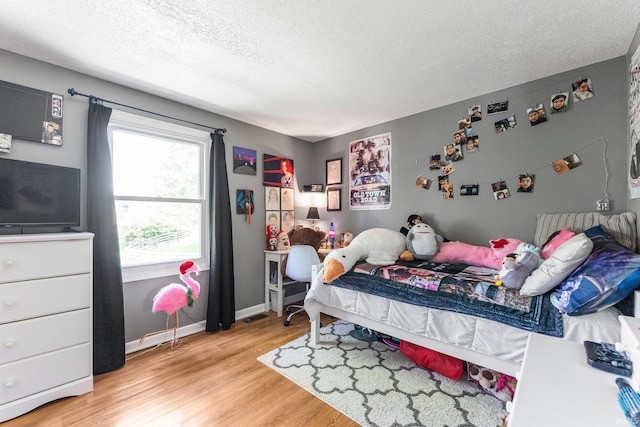 8809 Newberry Dr, Fort Wayne, IN 46825 - bedroom with light wood-style flooring, a textured ceiling, and baseboards