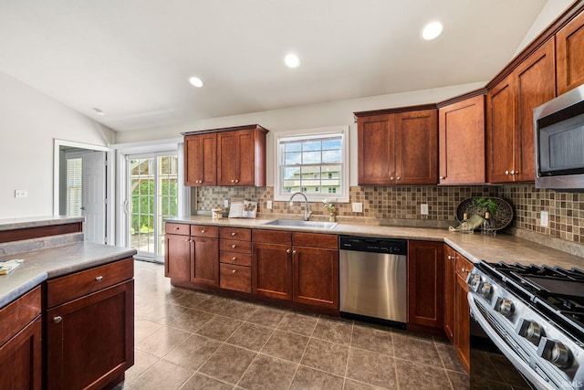 13849 Old Colony Dr, Granger, IN 46530 - kitchen with stainless steel appliances, a sink, vaulted ceiling, decorative backsplash, and light countertops