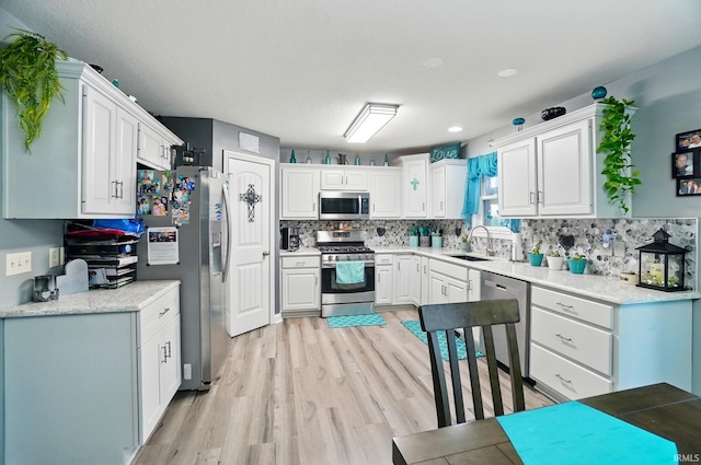 10221 Windsail Cv, New Haven, IN 46774 - kitchen featuring stainless steel appliances, a sink, light wood-type flooring, and white cabinets