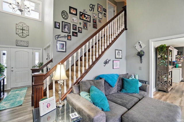 10221 Windsail Cv, New Haven, IN 46774 - living room featuring a towering ceiling, stairway, a chandelier, and wood finished floors