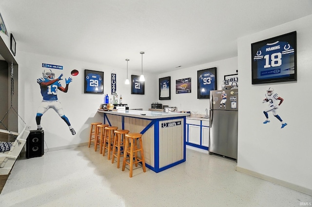 10221 Windsail Cv, New Haven, IN 46774 - kitchen featuring freestanding refrigerator, a breakfast bar area, baseboards, a peninsula, and pendant lighting