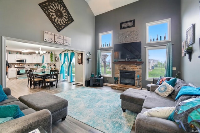 10221 Windsail Cv, New Haven, IN 46774 - living area featuring high vaulted ceiling, a chandelier, light wood-type flooring, and a fireplace