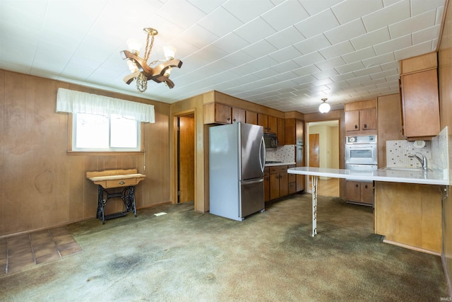 54188 Terrace Ln, South Bend, IN 46635 - kitchen featuring appliances with stainless steel finishes, a sink, light countertops, decorative backsplash, and a peninsula