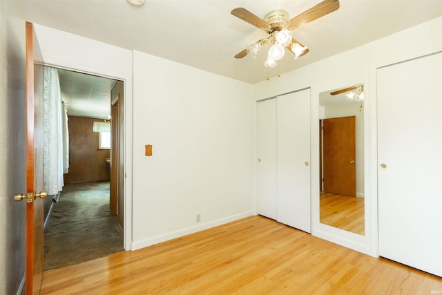 54188 Terrace Ln, South Bend, IN 46635 - unfurnished bedroom with light wood-type flooring, baseboards, multiple closets, and a ceiling fan