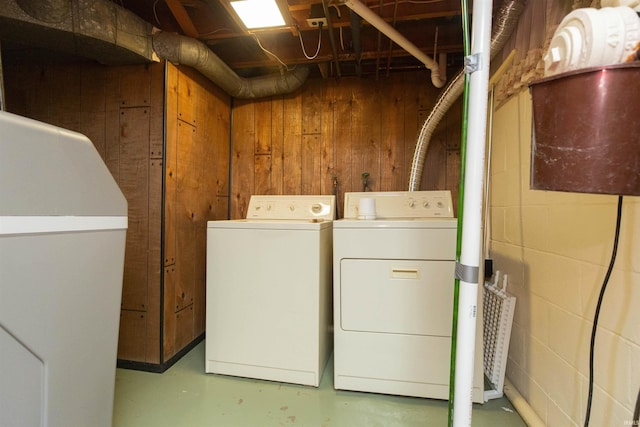 54188 Terrace Ln, South Bend, IN 46635 - washroom with washing machine and clothes dryer, wood walls, and concrete block wall