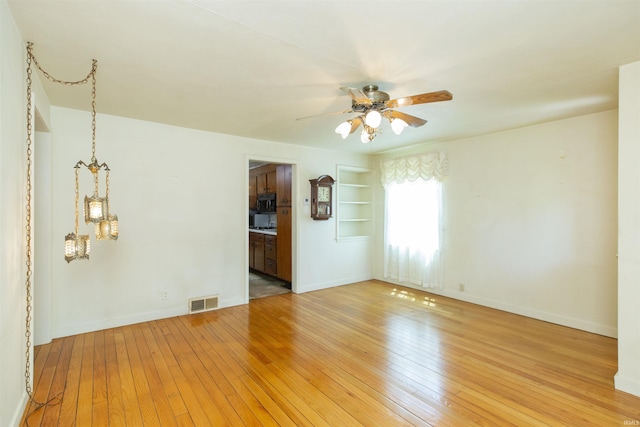 54188 Terrace Ln, South Bend, IN 46635 - unfurnished room with ceiling fan, light wood finished floors, built in shelves, and baseboards