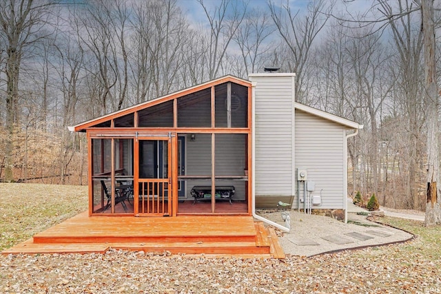 5959 W Delap Rd, Ellettsville, IN 47429 - rear view of house featuring a sunroom, a chimney, and a wooden deck