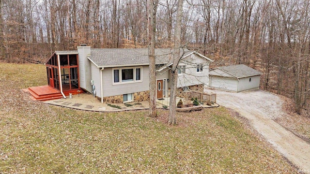 5959 W Delap Rd, Ellettsville, IN 47429 - view of front of house featuring a chimney, a front yard, an outdoor structure, roof with shingles, and a wooded view
