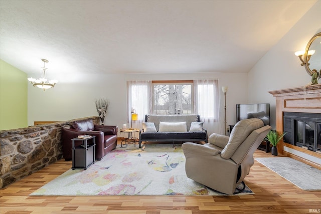 5959 W Delap Rd, Ellettsville, IN 47429 - living room with a chandelier, wood finished floors, a glass covered fireplace, and vaulted ceiling