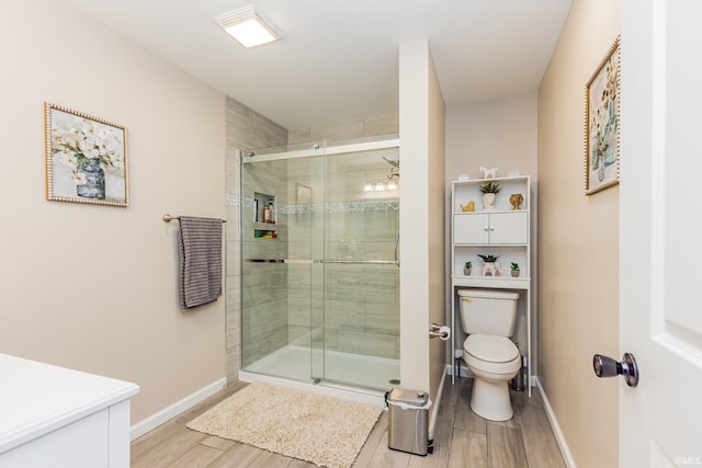 1804 W 14th St, Muncie, IN 47302 - bathroom featuring toilet, wood finished floors, a stall shower, baseboards, and vanity