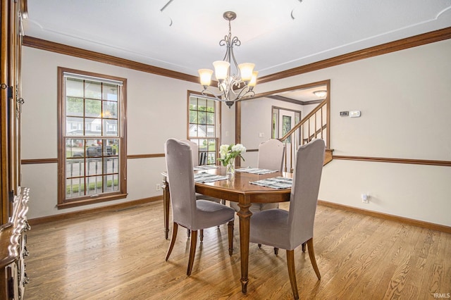 51178 Ashley Dr, Granger, IN 46530 - dining room with a chandelier, ornamental molding, light wood-style flooring, and baseboards