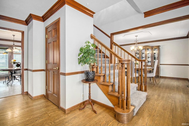 51178 Ashley Dr, Granger, IN 46530 - stairs with a chandelier, wood finished floors, crown molding, and baseboards