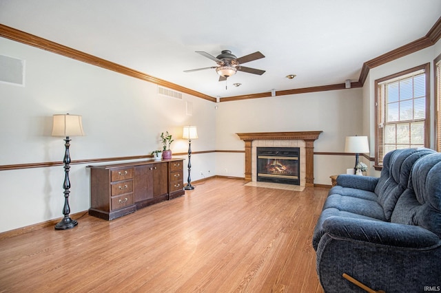 51178 Ashley Dr, Granger, IN 46530 - living area featuring a ceiling fan, crown molding, light wood-style flooring, baseboards, and a tile fireplace