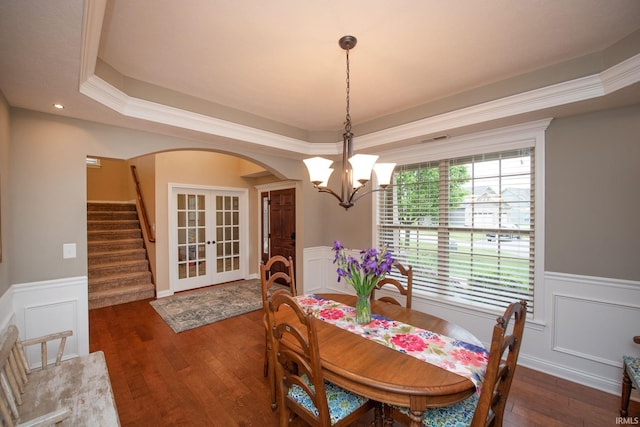 6118 Mackenzie Ct, West Lafayette, IN 47906 - dining area featuring french doors, arched walkways, a chandelier, a wainscoted wall, and hardwood / wood-style floors